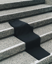 Jiji Pant in Black draped across granite steps